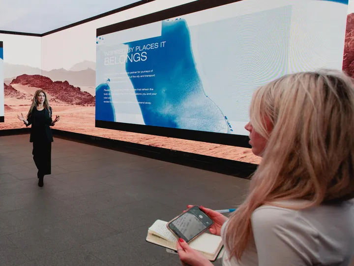 A guest filming a presenter on her phone at a car launch